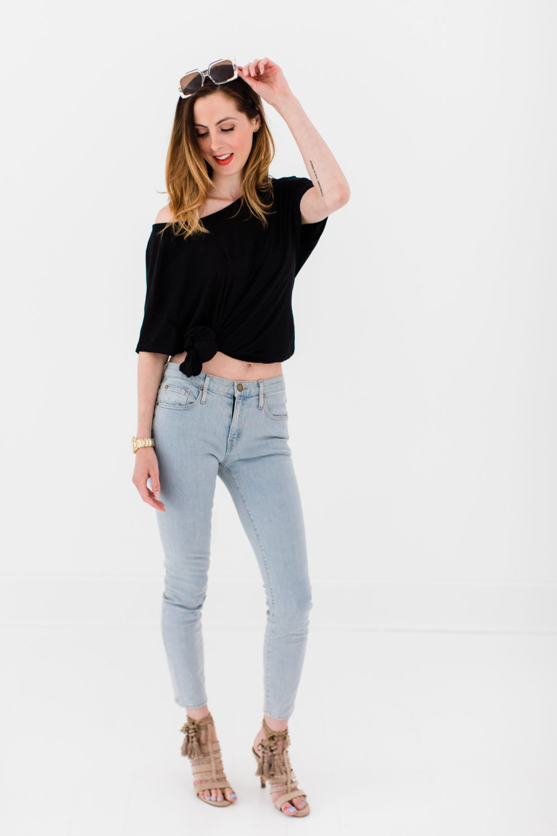 Eva Amurri Martino wears a black knotted top, jeans, and heels