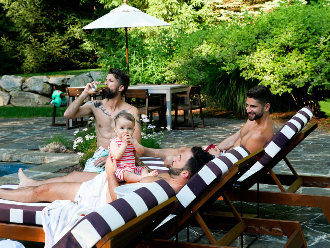 Major Martino hangs out with a group of men, including father Kyle Martino beside the pool at their Connecticut home