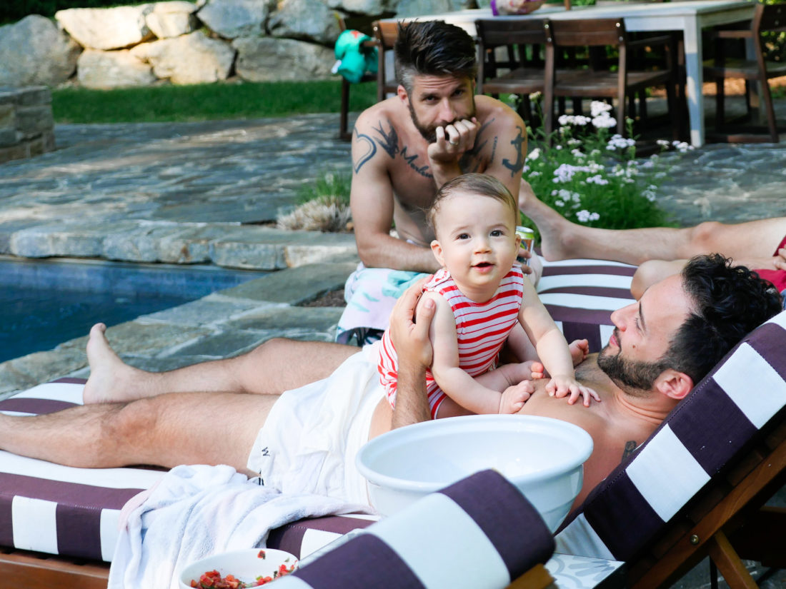 Major Martino hangs out with a group of men, including father Kyle Martino beside the pool at their Connecticut home