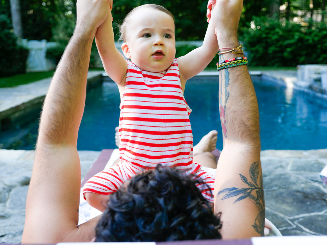 Major Martino hangs out with a group of men, including father Kyle Martino beside the pool at their Connecticut home