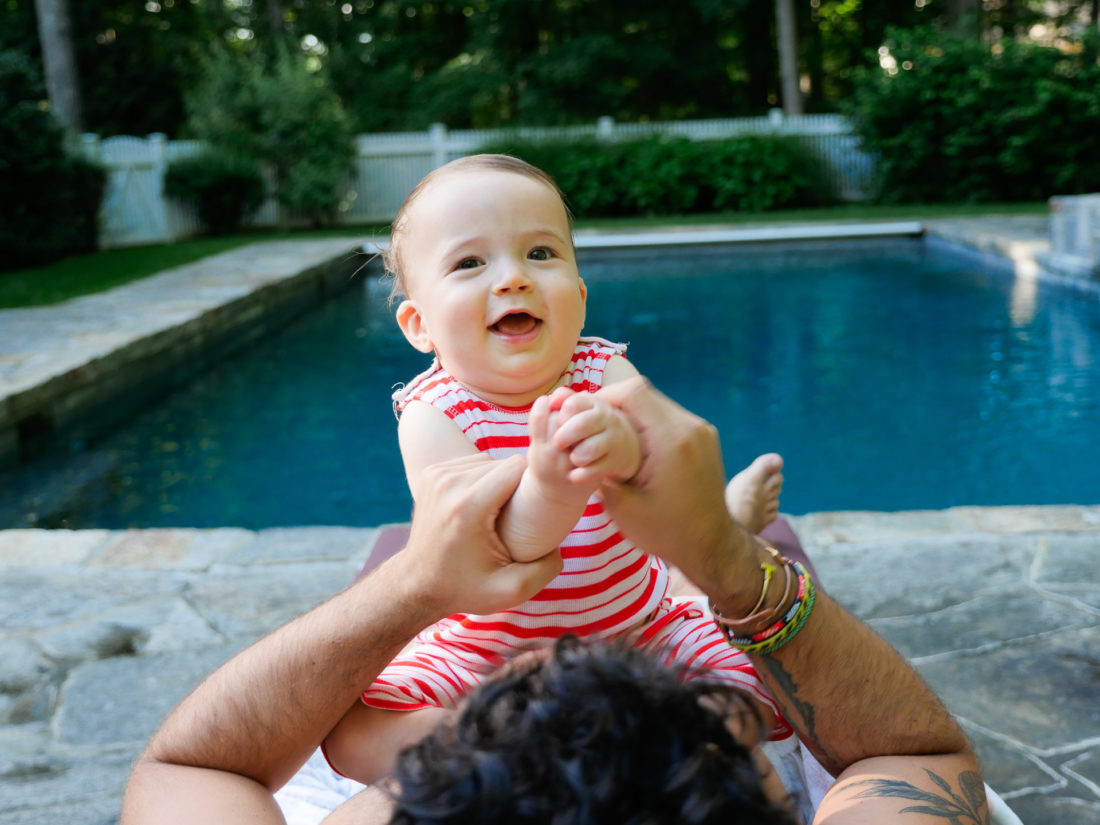 Major Martino hangs out with a group of men, including father Kyle Martino beside the pool at their Connecticut home