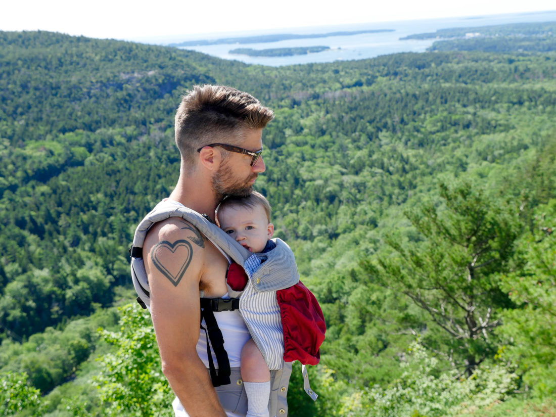Kyle Martino holds Major Martino in a baby carrier on a hike in Maine