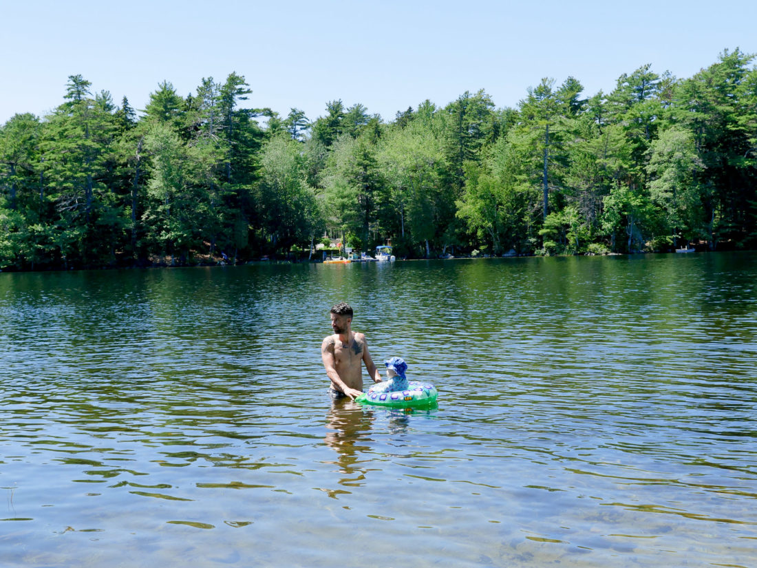 Kyle Martino stands in the lake surrounded by trees