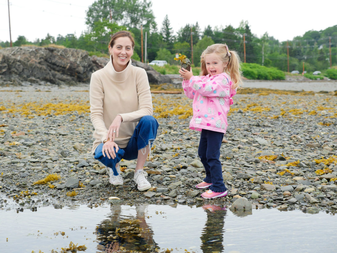 Eva Amurri Martino laughs and looks on as daughter Marlowe plays in the tidal pools on the beach in Maine