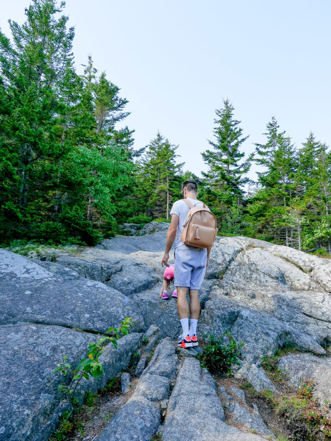 Kyle Martino hikes with two year old daughter Marlowe on a trail in Acadia National Park