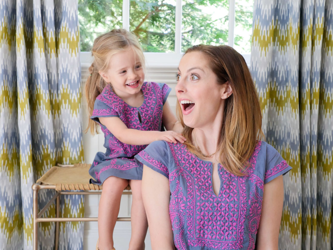 Eva Amurri Martino and Marlowe Martino wear matching embroidered dresses and sit together in the living room of their Connecticut home