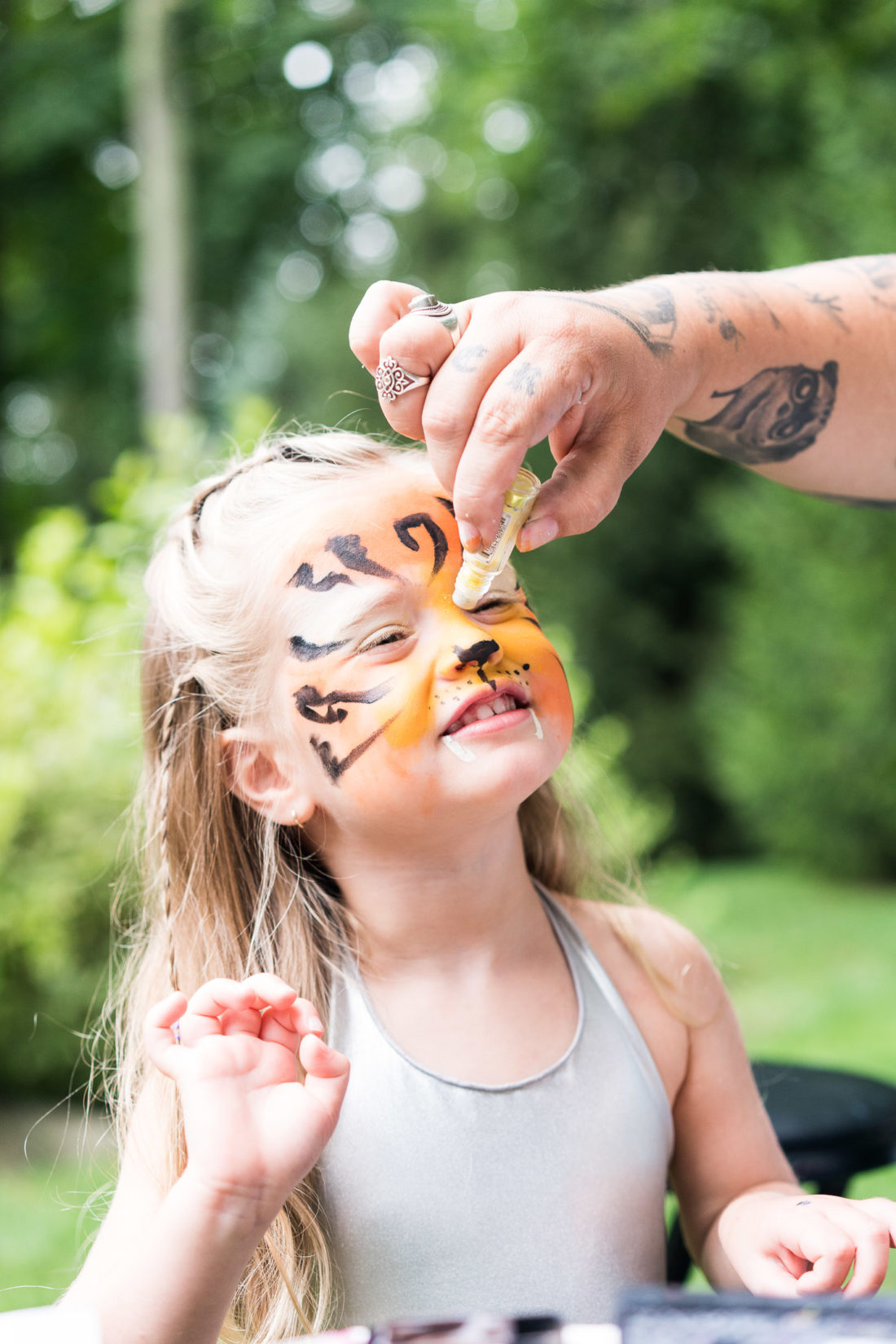 Marlowe Martino gets her face painted like a tiger at her third birthday party