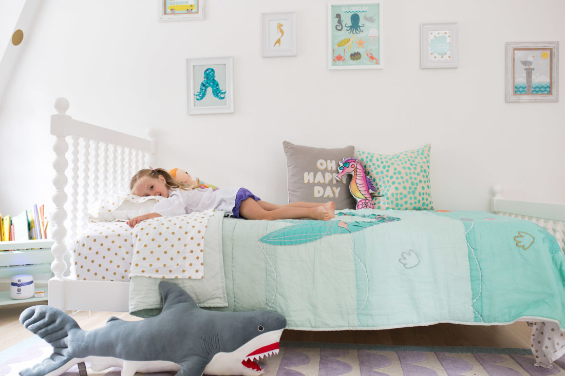 Marlowe lays on her Big Girl Bed in her mermaid themed bedroom in Connecticut