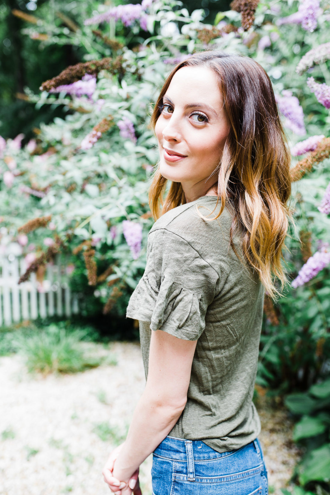 Eva Amurri Martino wears an army green flutter sleeve linen Tshirt in the courtyard of her Connecticut home