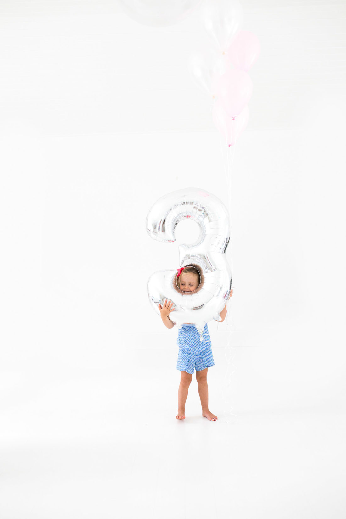 Marlowe Martino poses with a large balloon for her third birthday portraits