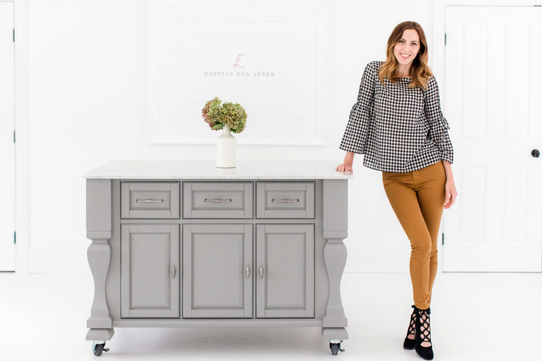 Eva Amurri Martino wears a pair of tan jeans, a black and white blouse, and poses in the Happily Eva After studio