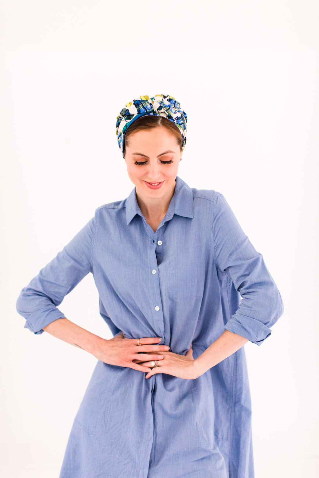 Eva Amurri Martino wears a light blue shirt dress and a turban head wrap made from a knotted silk scarf