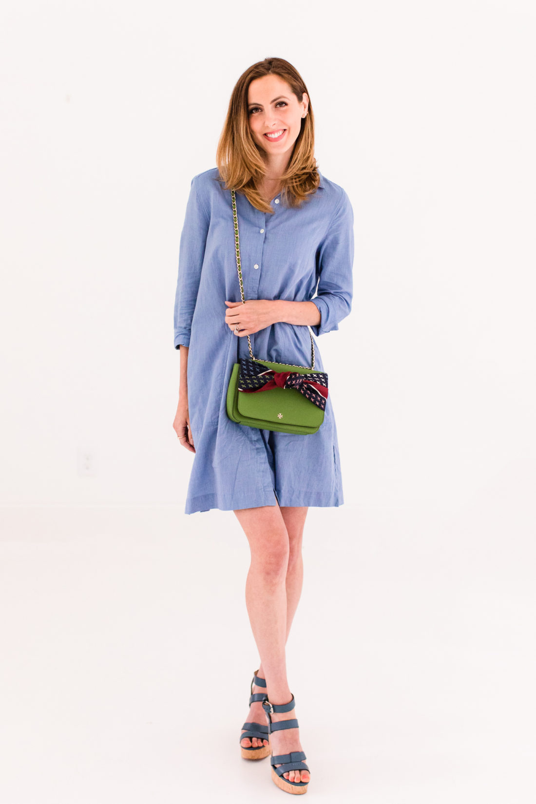 Eva Amurri Martino wears a blue shirt dress and styles a silk scarf to adorn her green tory burch bag