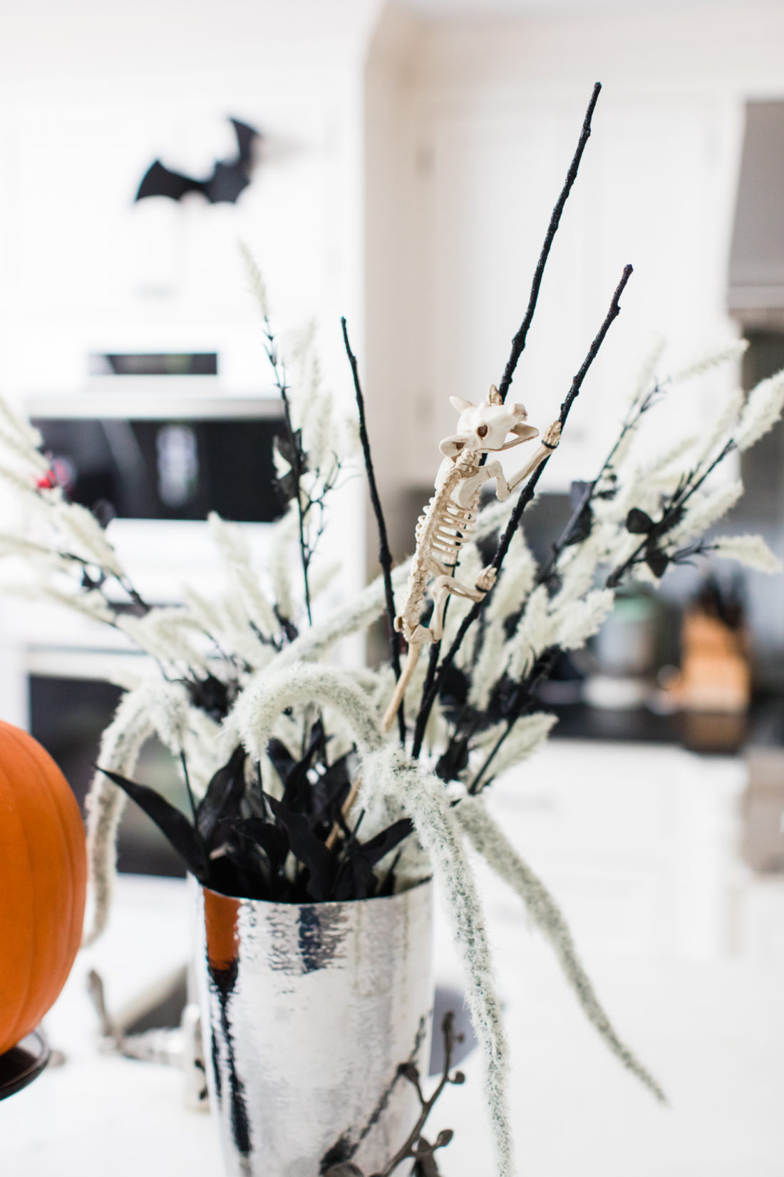 A mouse skeleton climbs up the reeds in a halloween themed flower display in Eva Amurri Martino's Connecticut kitchen