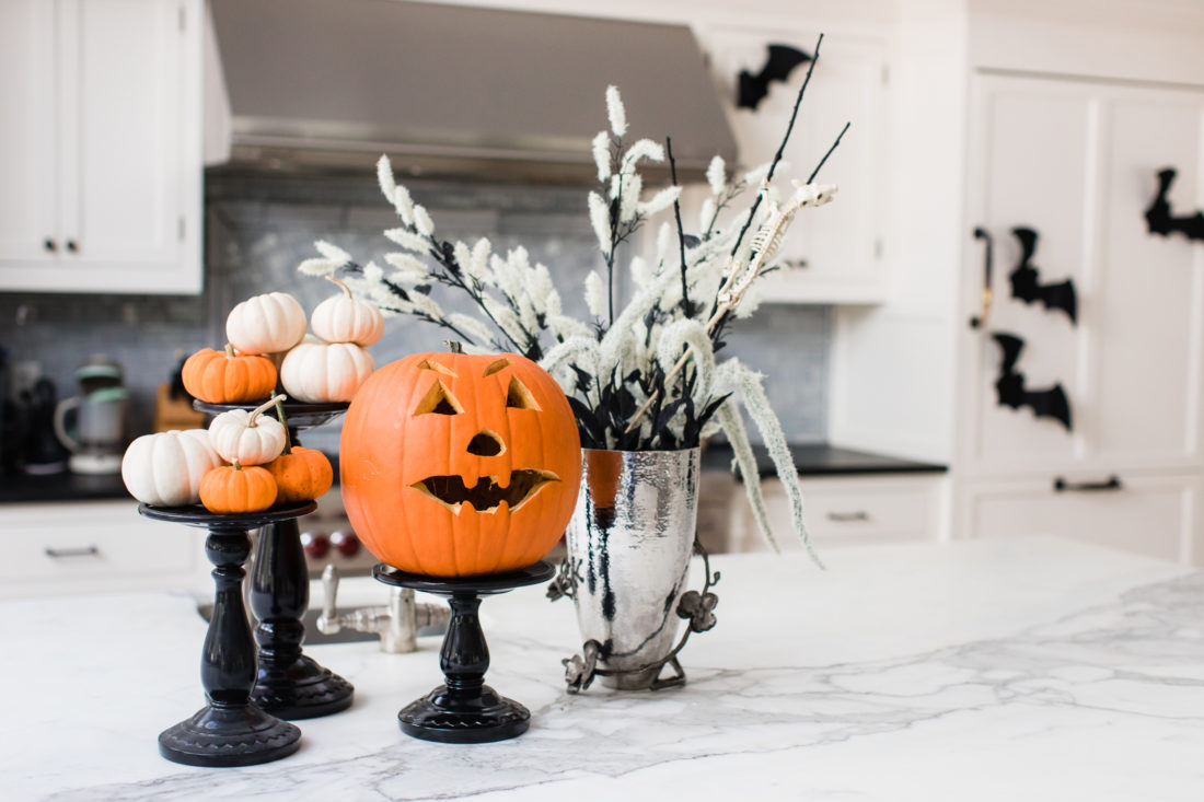 An assortment of Pumpkins on black lacquere stands decorate the marble island in Eva Amurri Martino's Connecticut kitchen