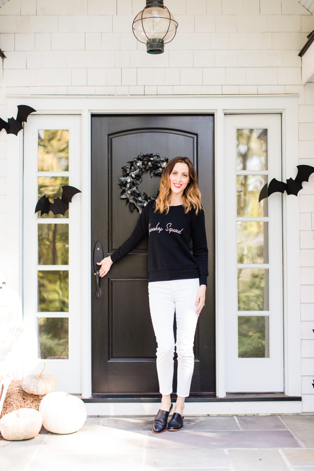 Eva Amurri Martino stands at the entryway to her Connecticut home that is decorated with a spooky bat theme for Halloween
