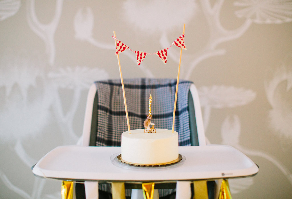 Major Martino's first birthday cake, featuring a red and white patterned flag bunting and a porcelain teddy bear riding a bicycle