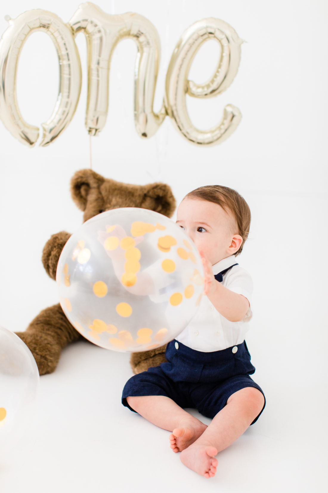 Major Martino holds a gold confetti filled balloon to celebrate his first birthday