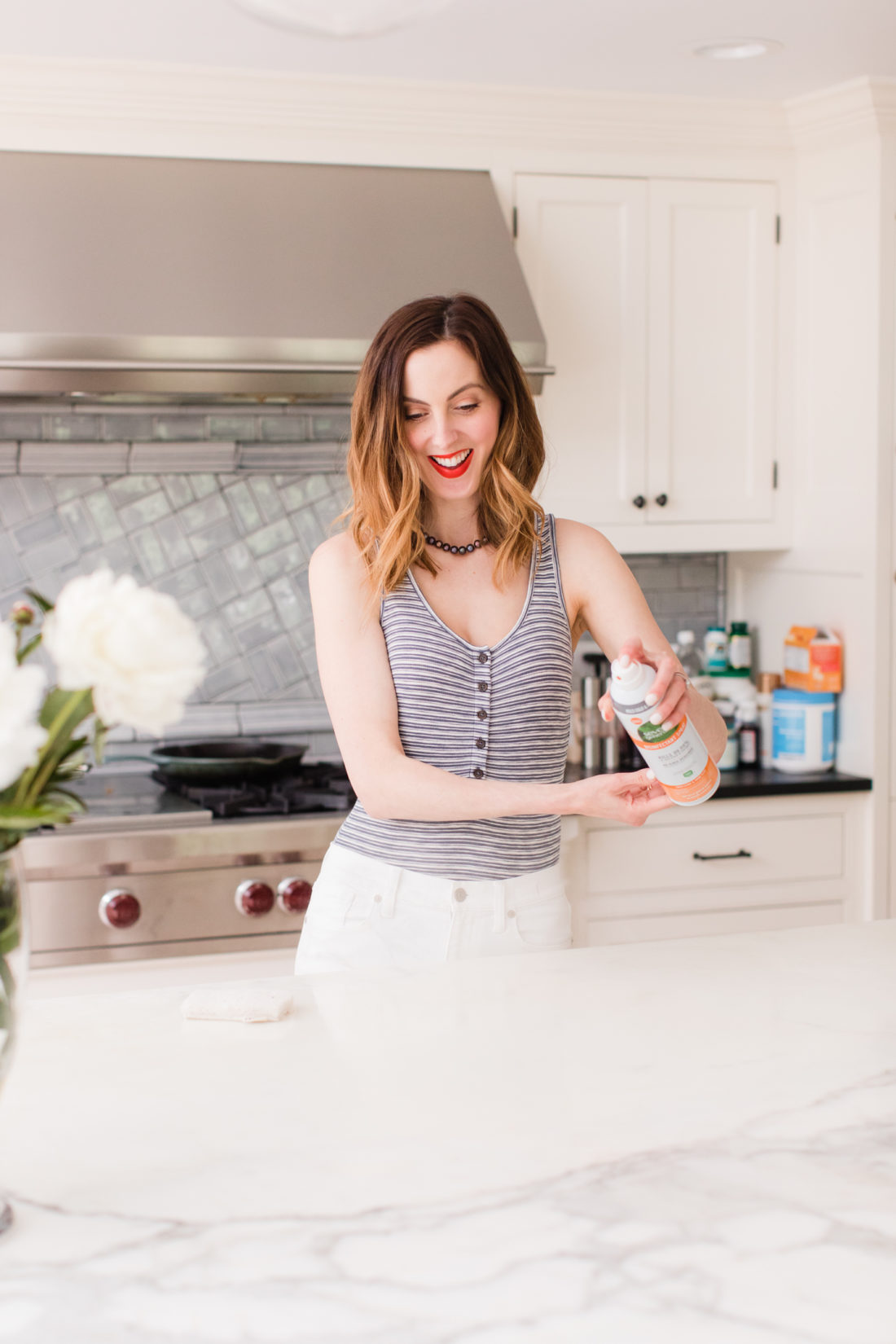 Eva Amurri Martino sprays the countertops with Seventh Generation disinfecting spray in the kitchen of her connecticut home