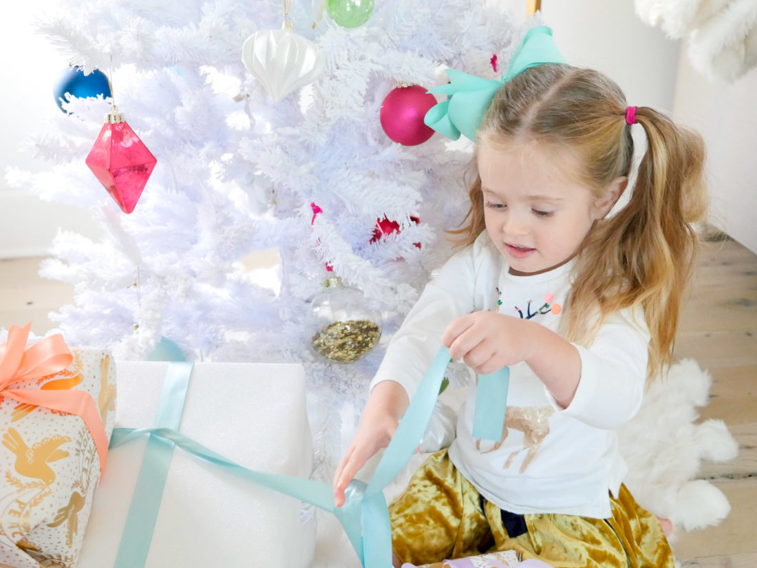 Marlowe Martino unwraps a colorful Christmas present in the family room of her Connecticut home