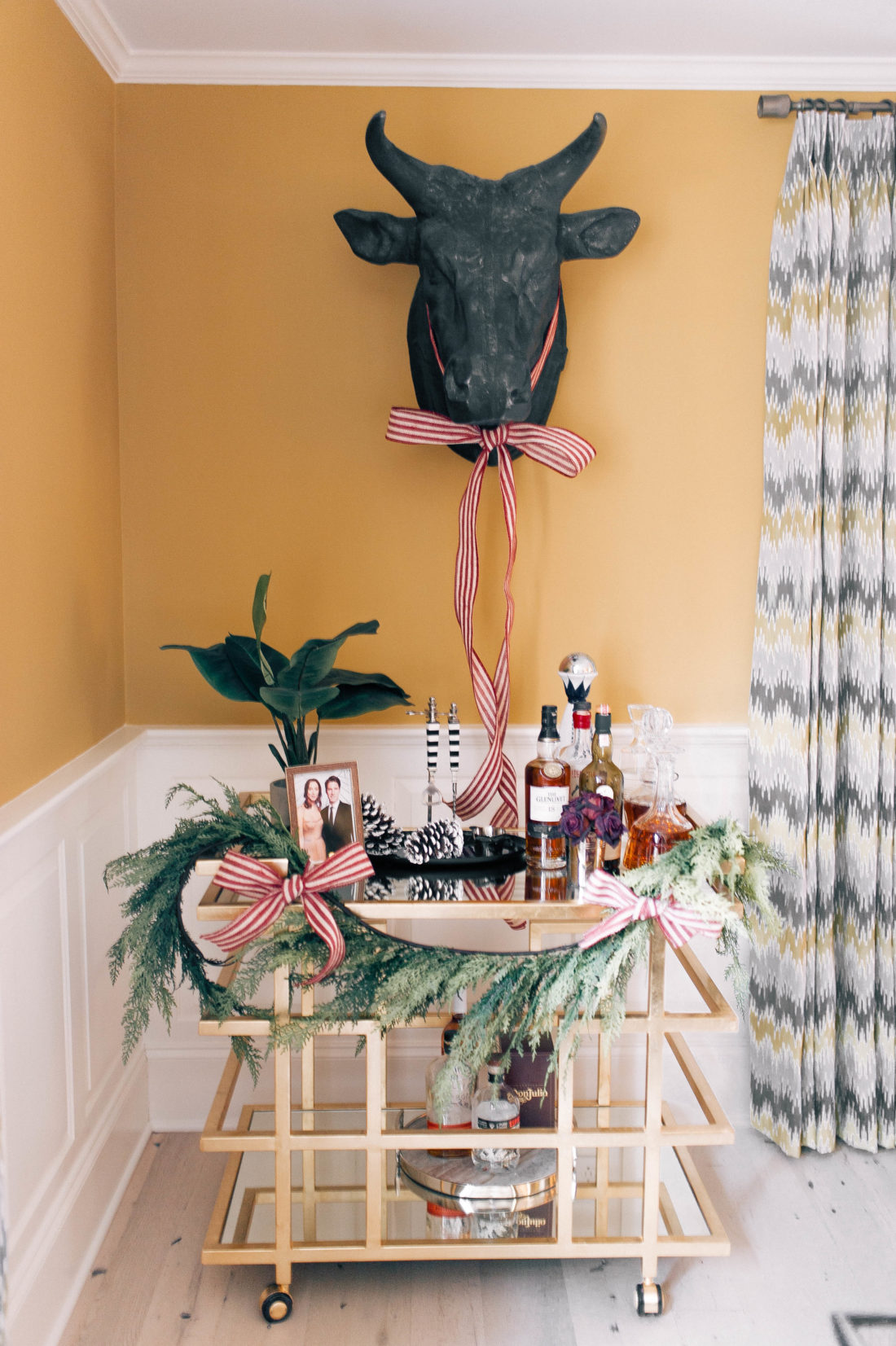 The bar cart in Eva Amurri Martino's connecticut home is dressed up for the holiday season with a garland and ribbon