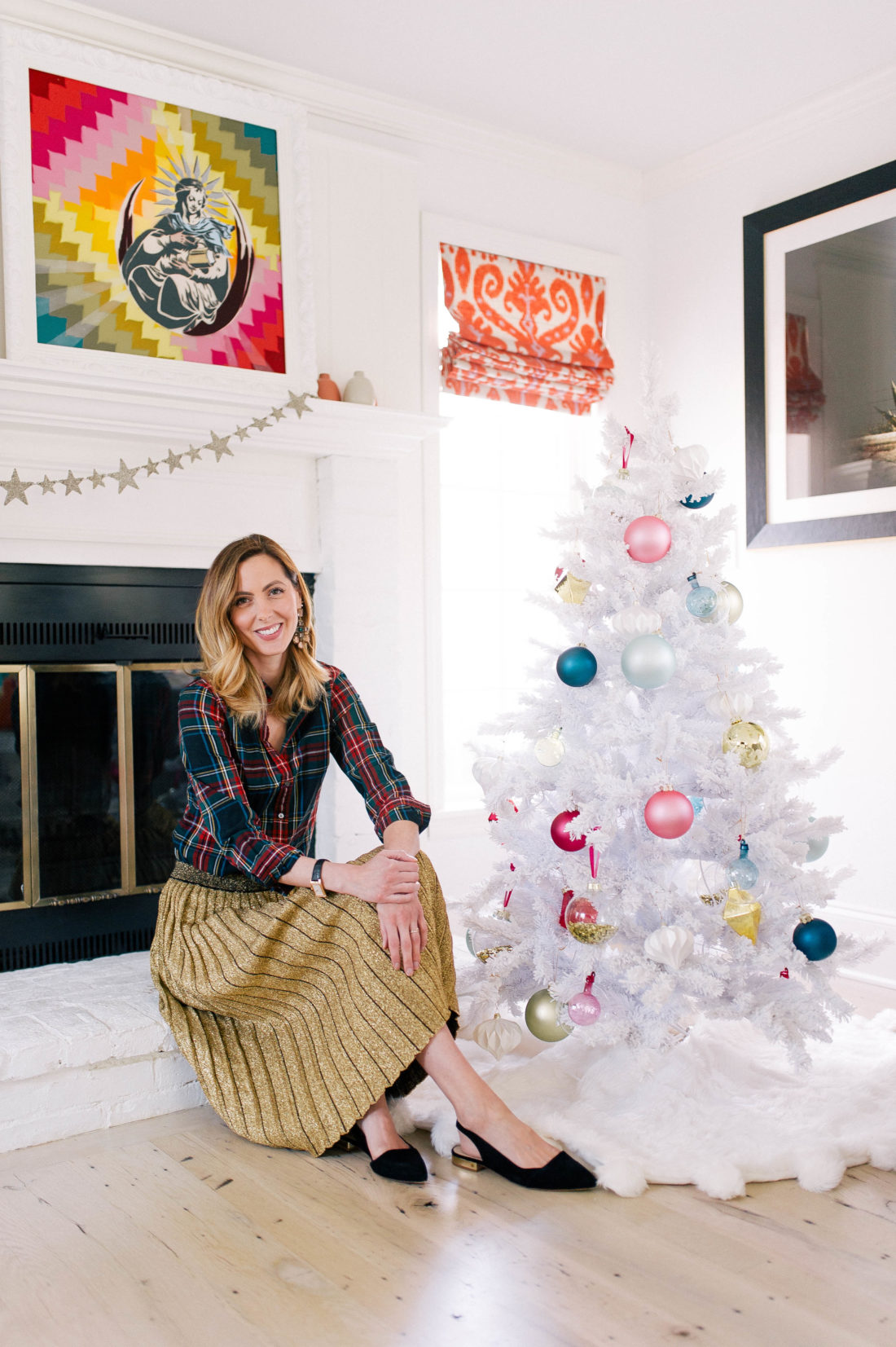 Eva Amurri Martino sits next to her white christmas tree decorated with colorful ornaments in the family room of her Connecticut home