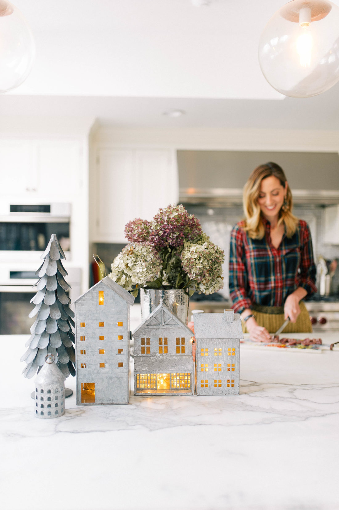 Eva Amurri Martino prepares lunch in her kitchen that is decorated for christmas with galvanized steel houses filled with twinkly lights