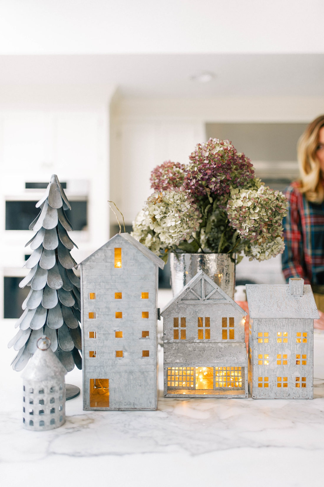 Eva Amurri Martino prepares lunch in her kitchen that is decorated for christmas with galvanized steel houses filled with twinkly lights