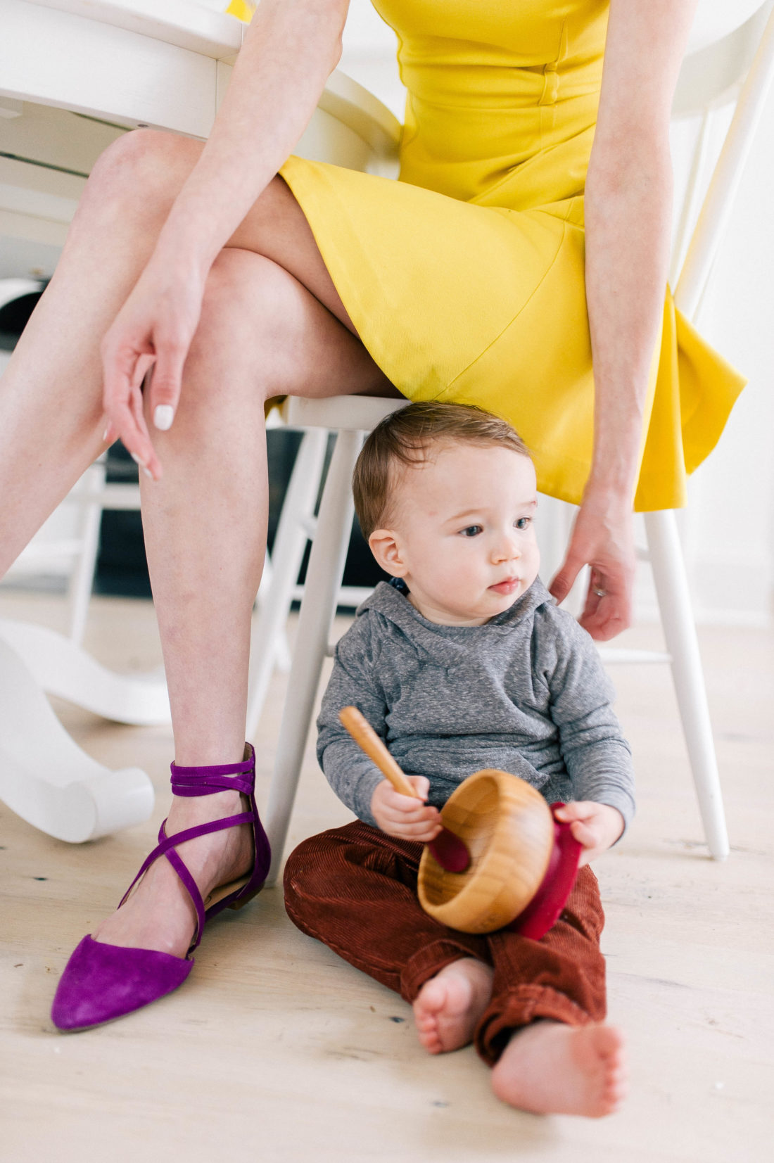 Major Martino sits on the kitchen floor next to his Mom's chair and plays with a SpoonfulOne feeding bowl