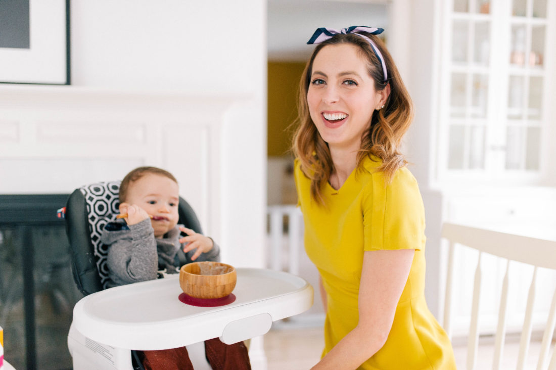 Eva Amurri Martino wears a yellow dress and oversees her son Major eating a bowl of porridge with a SpoonfulOne mixin