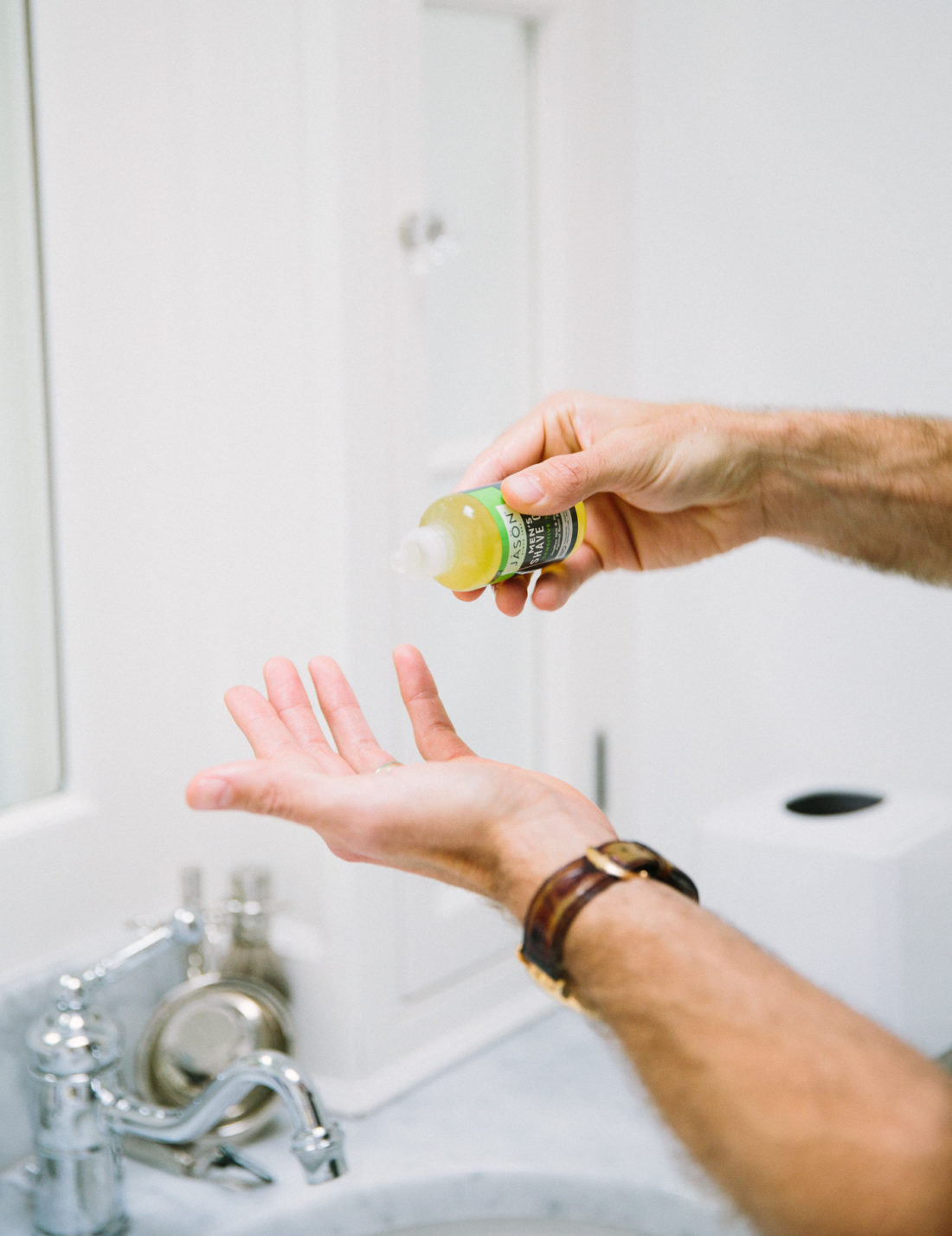 Kyle Martino uses shave oil to shave off his beard in the bathroom of his Connecticut home