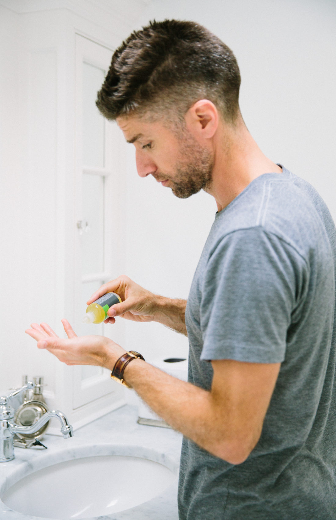 Kyle Martino uses shave oil to shave off his beard in the bathroom of his Connecticut home