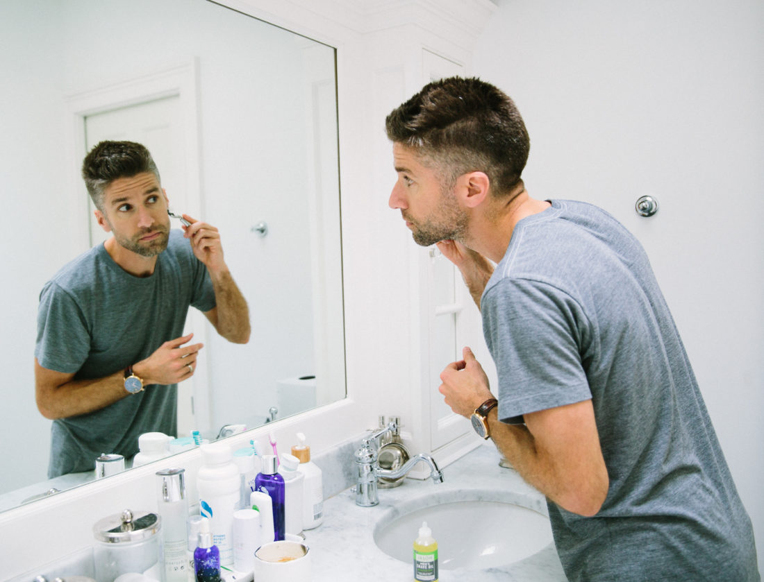 Kyle Martino wears a gray Tshirt and shaves his beard in the bathroom of his Connecticut home