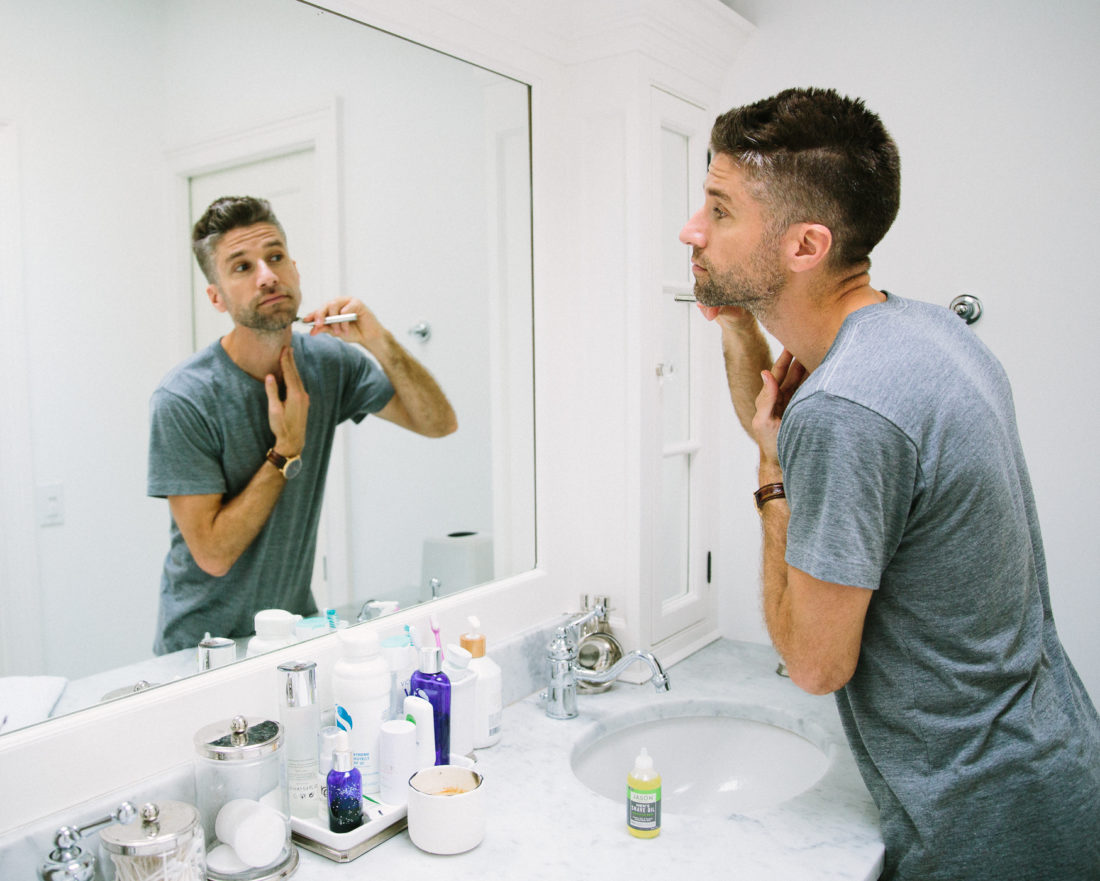 Kyle Martino wears a gray Tshirt and shaves his beard in the bathroom of his Connecticut home