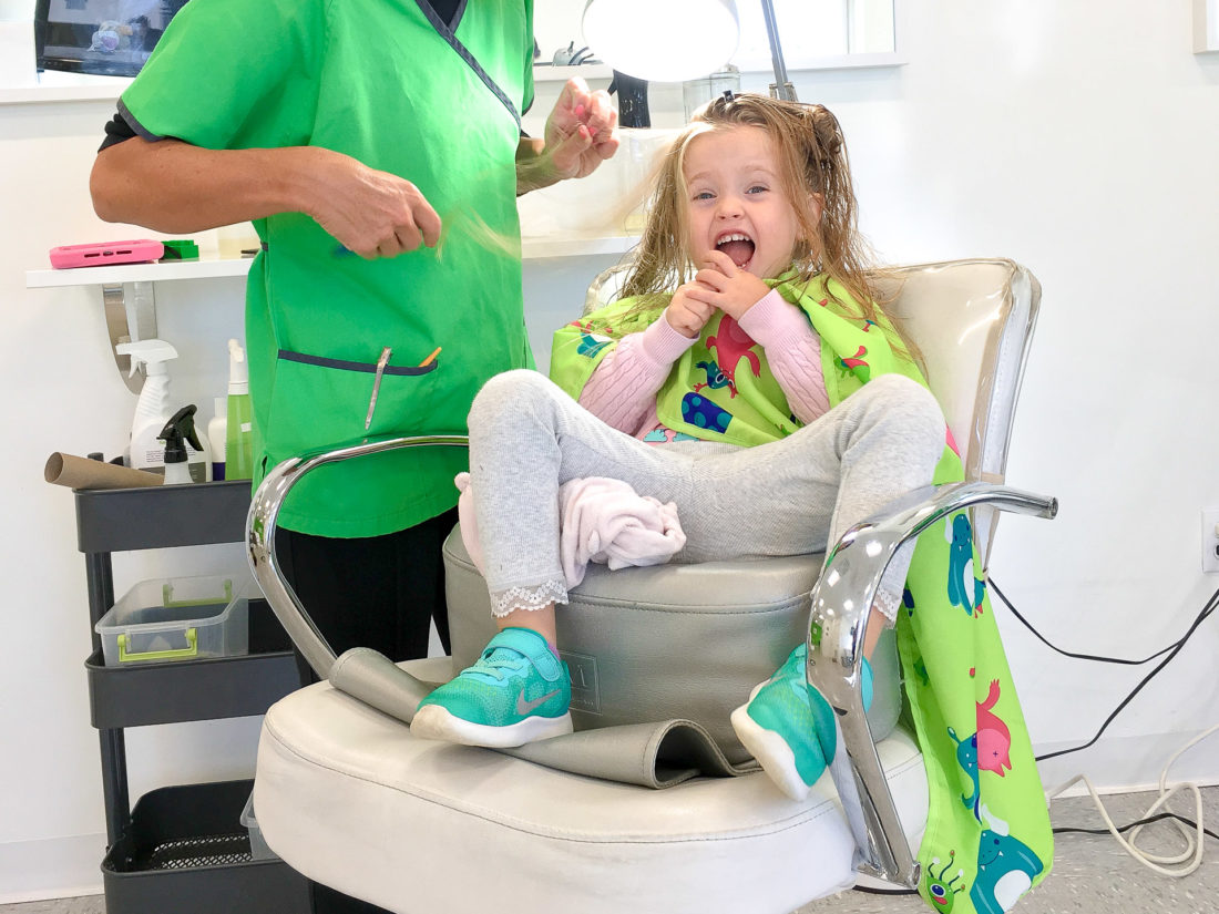 Marlowe Martino eats a lollipop while she gets her hair checked for lice