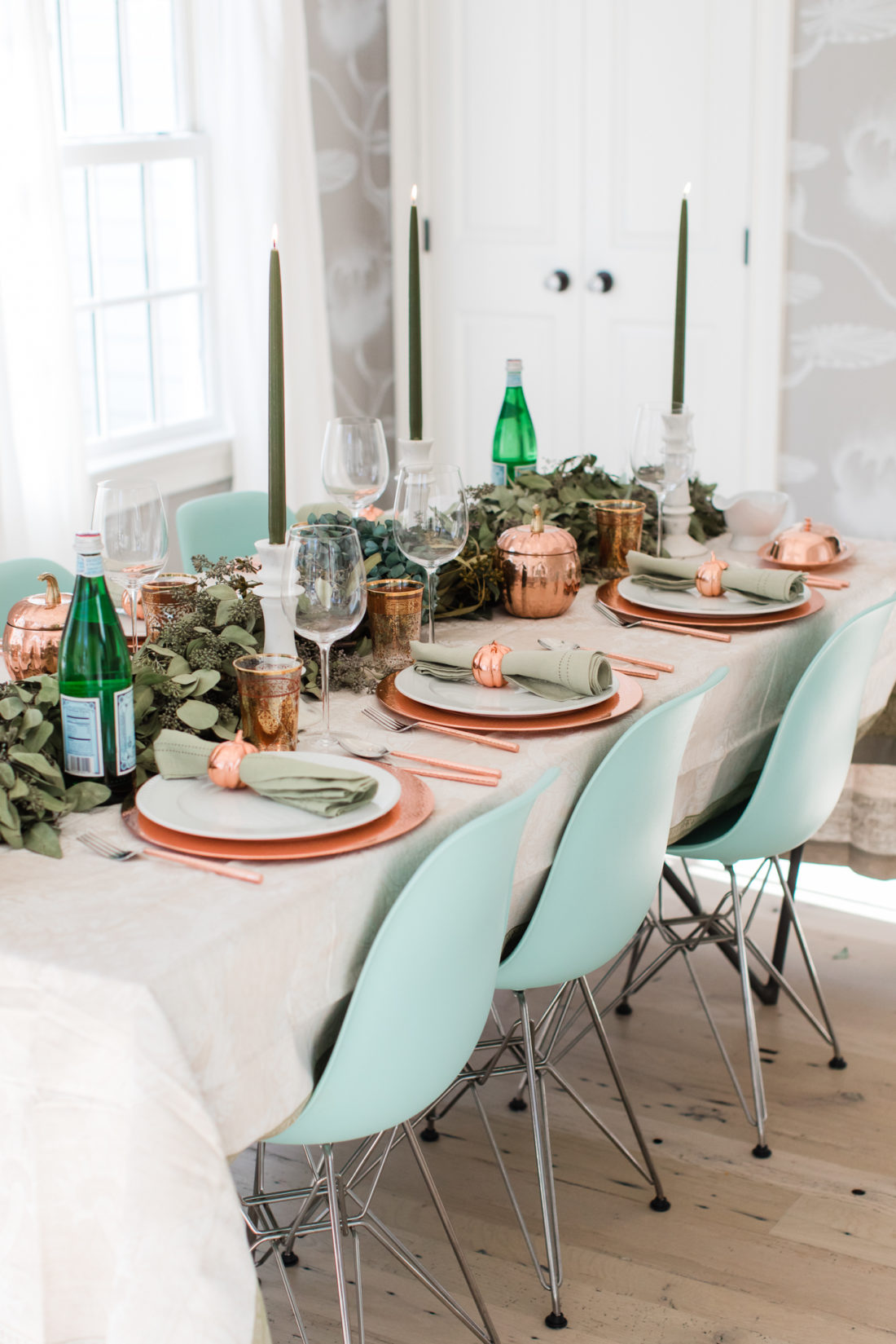 A eucaluptus garland, marble candlesticks with green candles, and a green and copper color scheme add style to Eva Amurri Martino's thanksgiving table