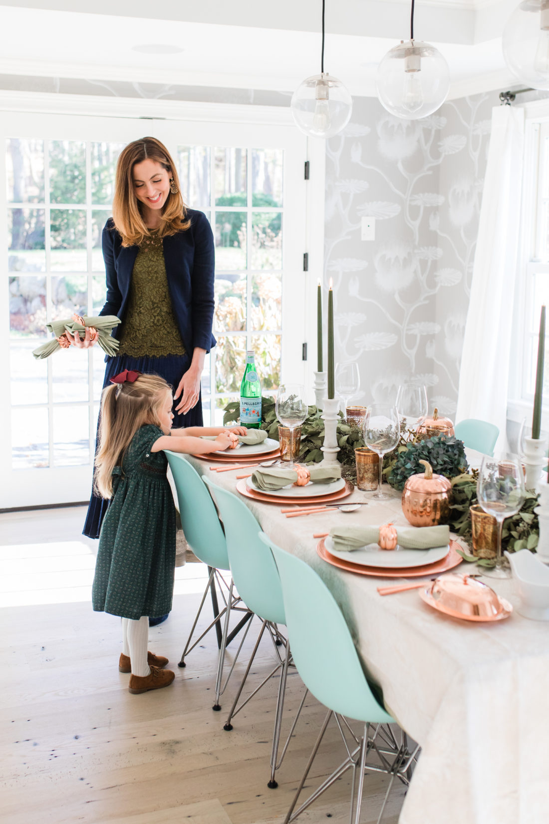 Marlowe Martino helps her Mom set the Thanksgiving table wearing a green velvet smocked party dress