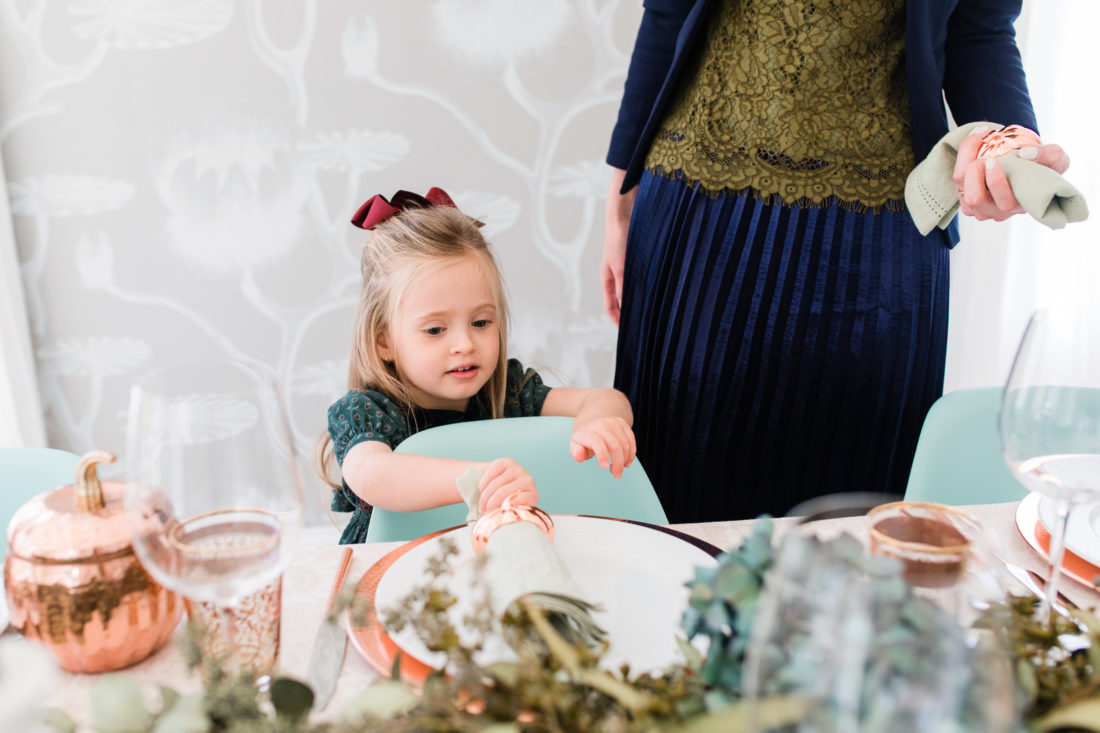 Marlowe Martino helps her Mom set the Thanksgiving table wearing a green velvet smocked party dress