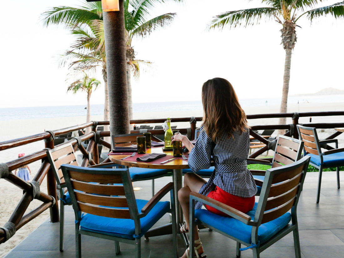 Eva Amurri martino sits outside at a restaurant overlooking the beach in Los Cabos, Mexico