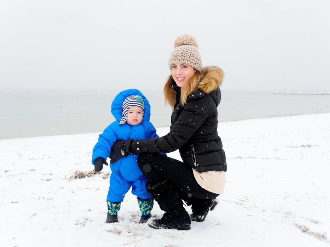 Eva AMurri Martino holds son, Major, in a snowsuit on the snowy beach in Westport, CT