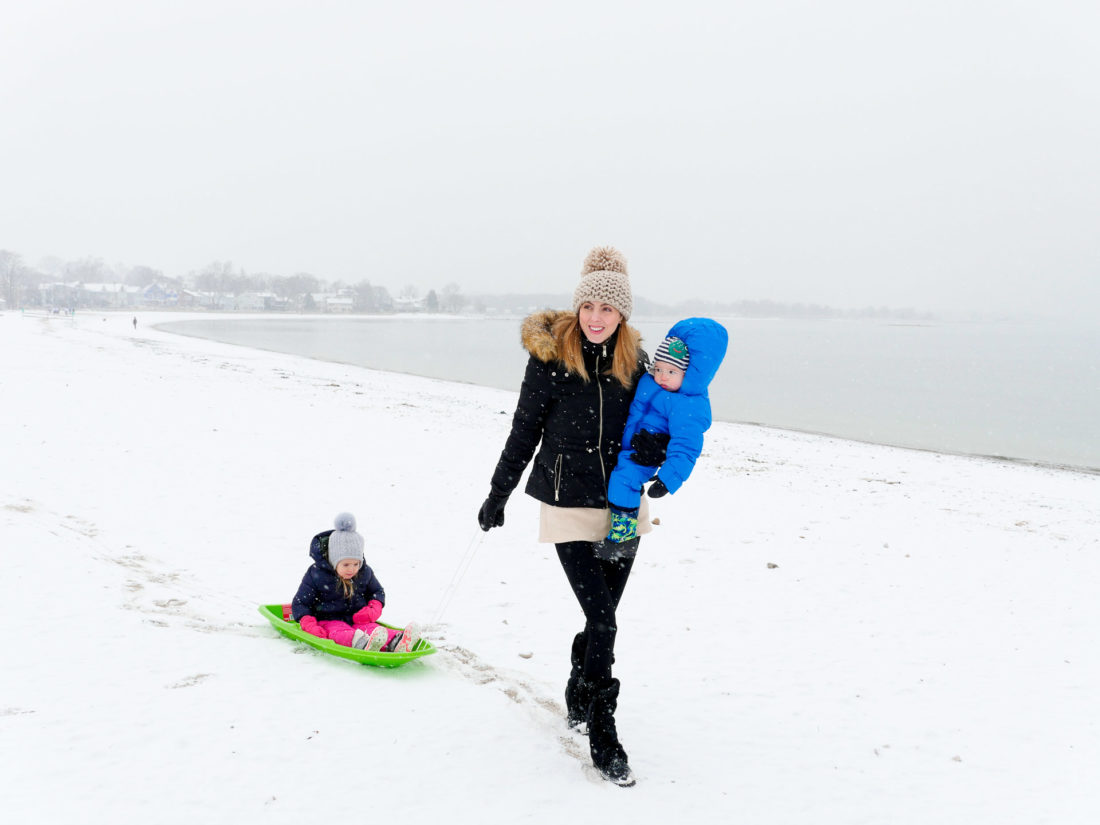 Eva Amurri Martino carries her one year old son, and pulls her three year old daughter through the snow on the beach in Westport, CT