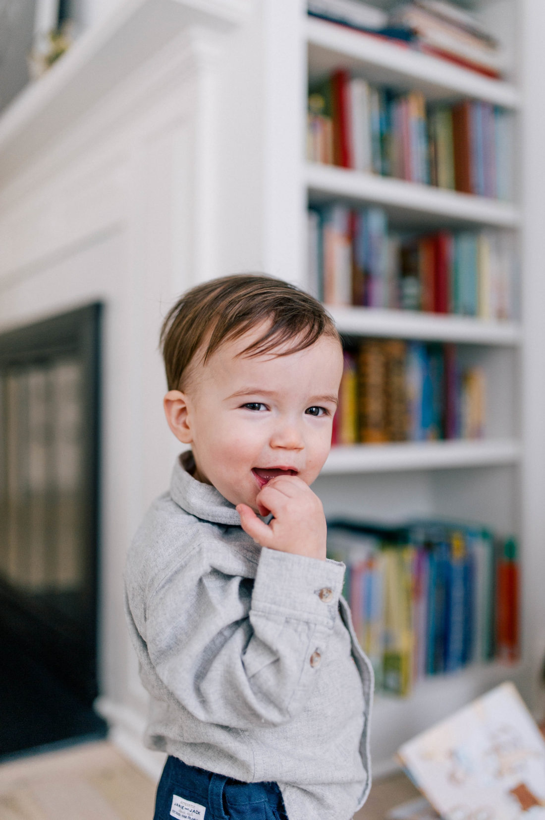 Major Martino wears a grey button down flannel shirt and a tartan bow tie and walks around the kitchen in his Connecticut home