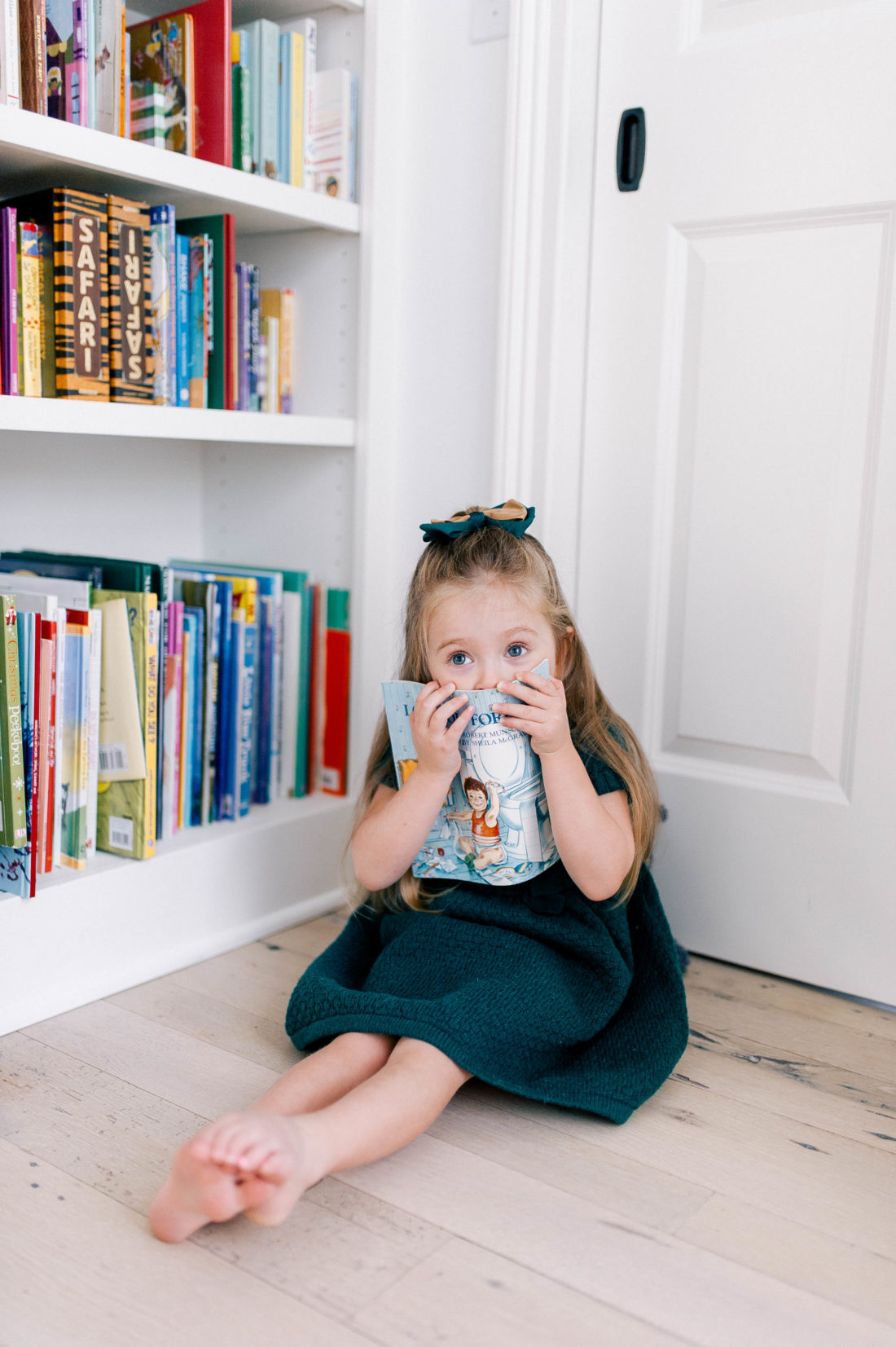 Marlowe Martino hides behind a book in the kitchen of her Connecticut home