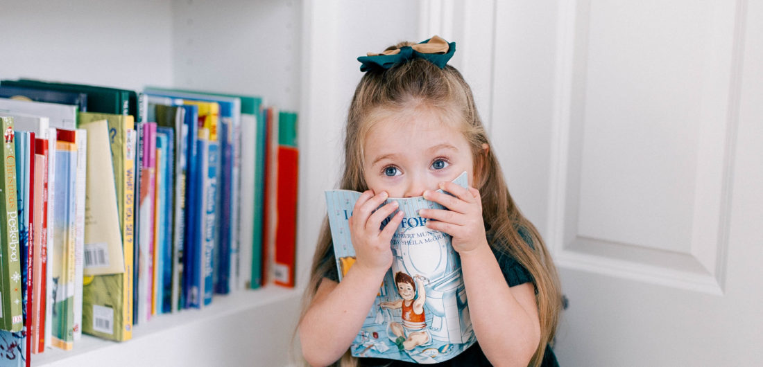 Marlowe Martino hides behind a book in the kitchen of her Connecticut home