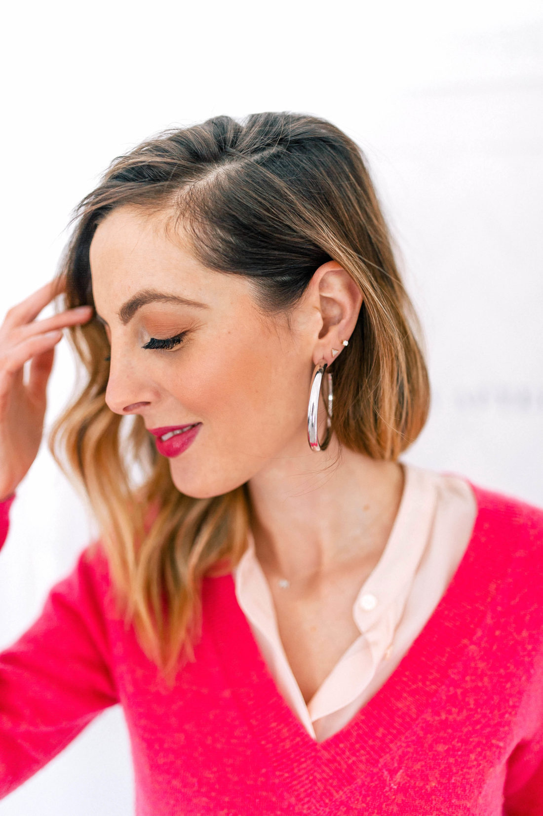 Eva Amurri Martino wears a hot pink sweater and silver hoop earrings
