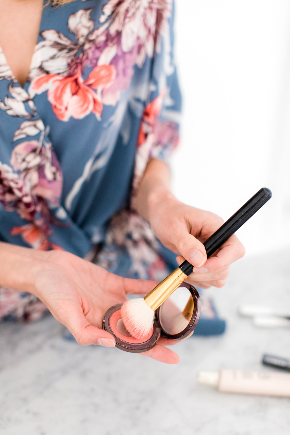 Eva Amurri Martino applies blush to the apples of her cheeks and cheekbones as part of her photo shoot beauty tutorial