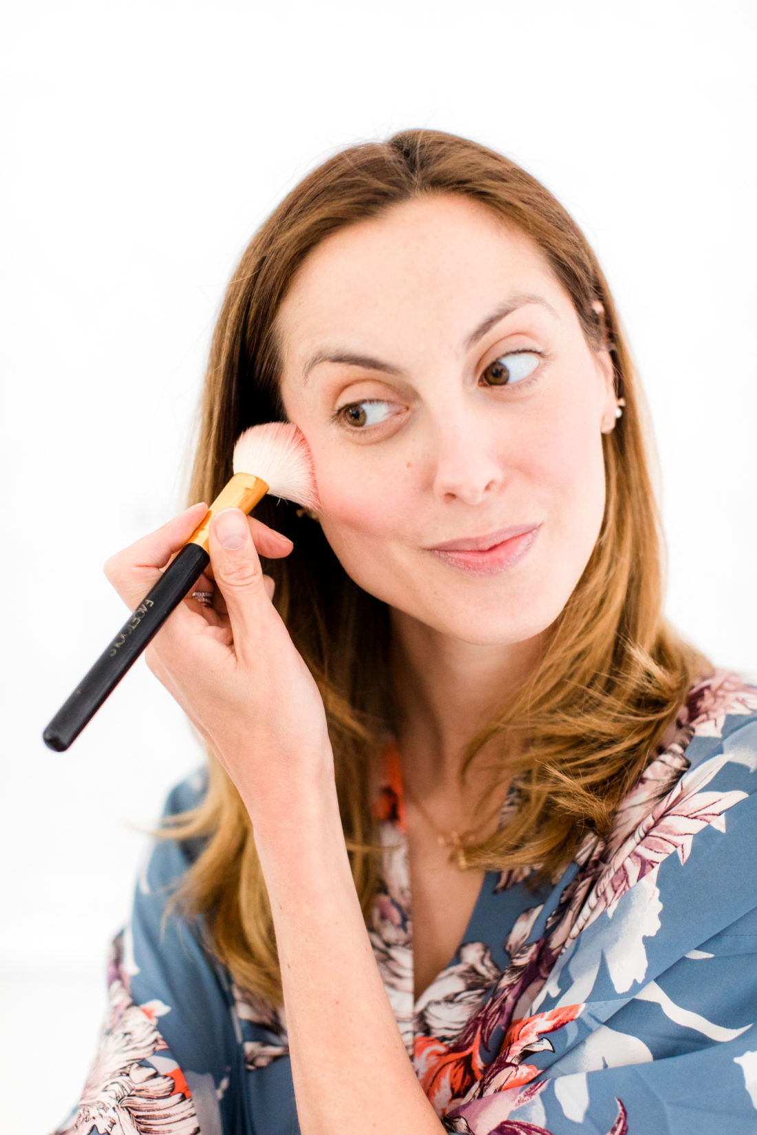 Eva Amurri Martino applies blush to the apples of her cheeks and cheekbones as part of her photo shoot beauty tutorial