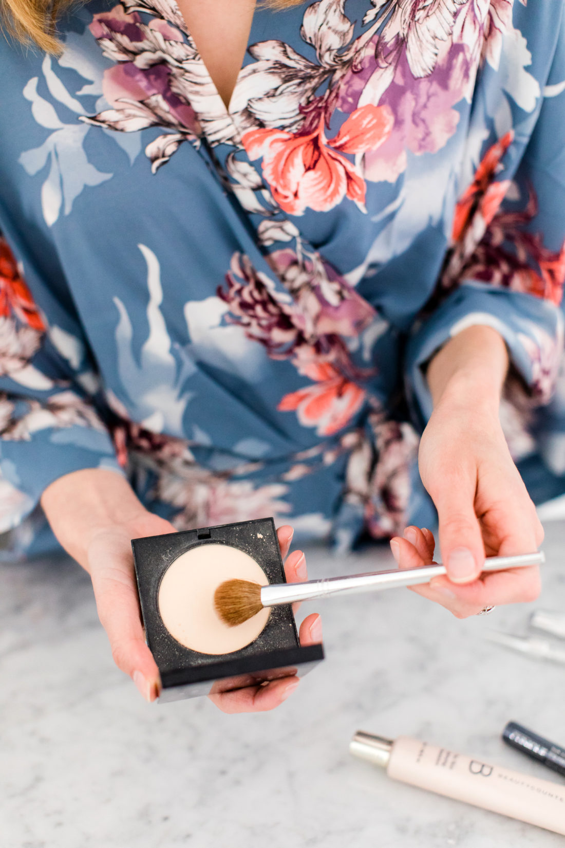 Eva Amurri Martino applies translucent powder to her skin over her foundatino and concealer as part of her makeup tutorial 