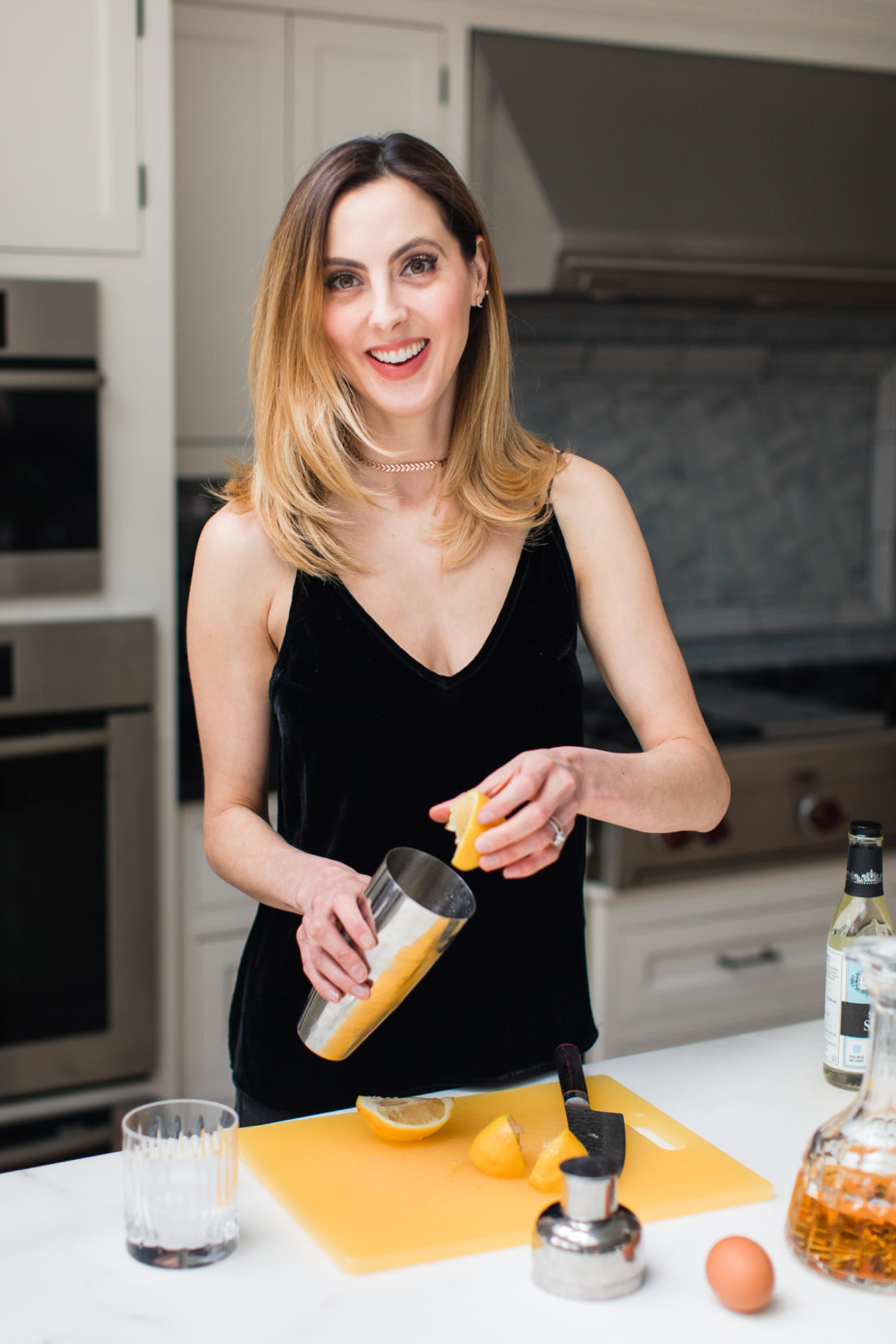 Eva Amurri Martino wears a black velvet spaghetti strap top and mixes up a whiskey sour in the kitchen of her Connecticut home