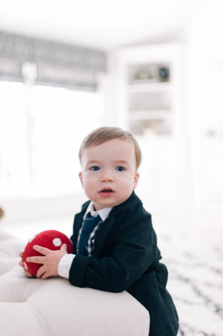 Major James Martino wearing a holding a navy blue suit with a gingham shirt and holding a red ball in his Connecticut home